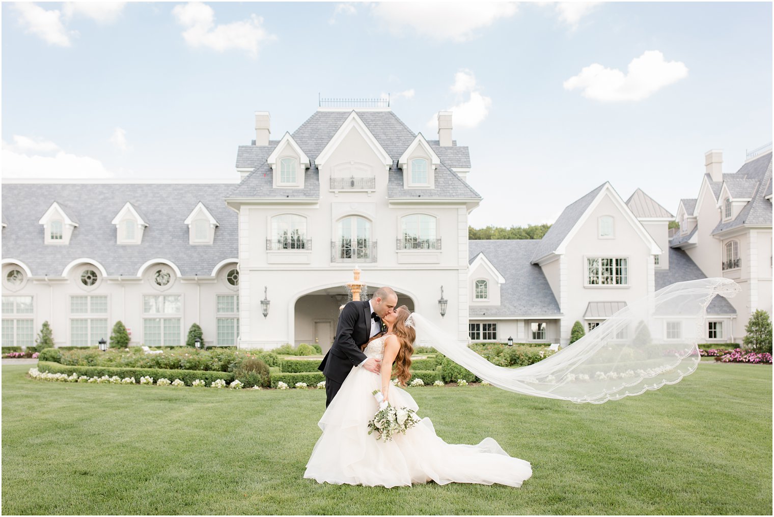 Bride and groom portrait with veil blowing in the wind at Park Chateau Estate