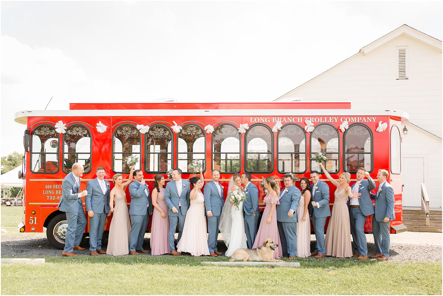 Wedding party in front of red trolley 