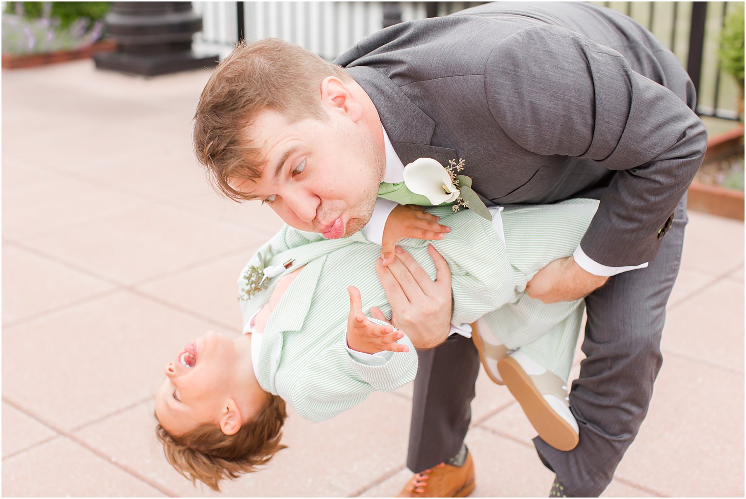 Candid photo of groom and ring bearer