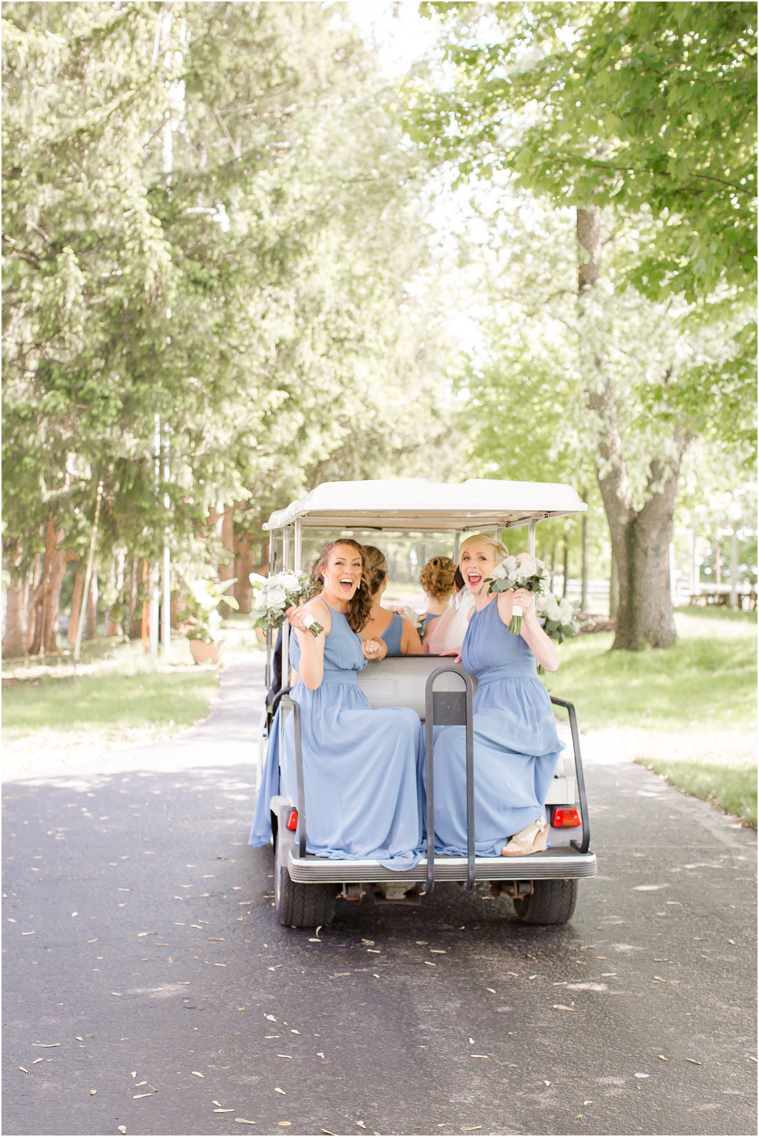 Bridesmaids riding golf cart at Windows on the Water Frogbridge