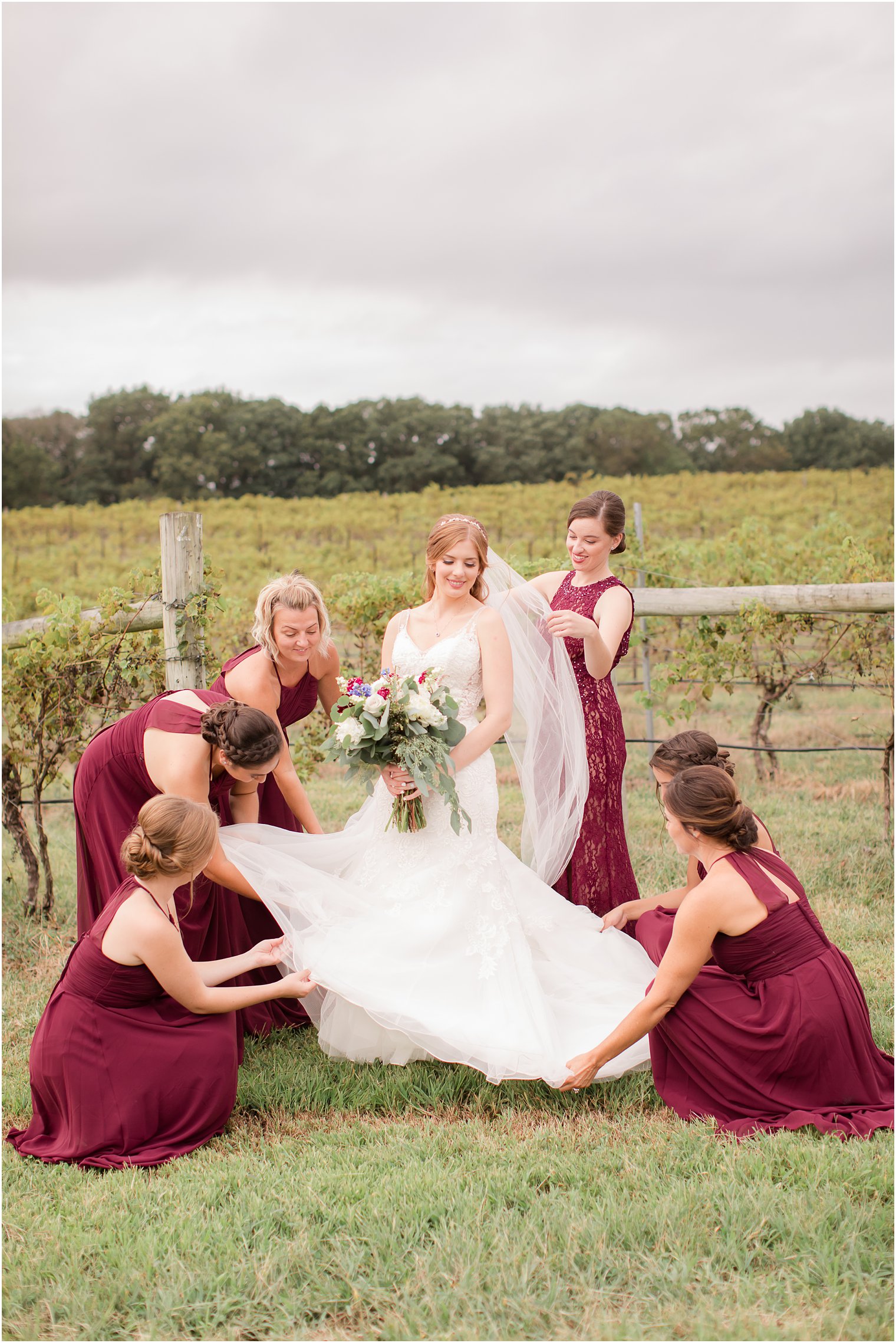 Bridesmaids helping bride with dress and veil