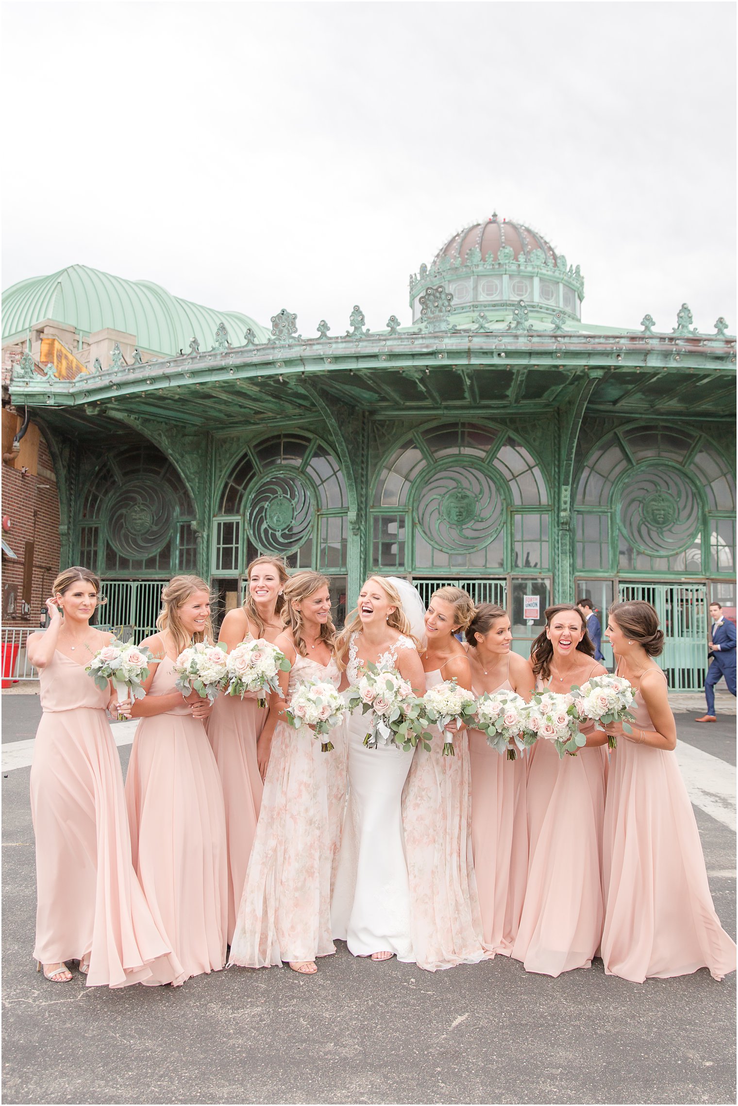 Bridesmaids laughing during portraits at Asbury Park during a windy wedding day