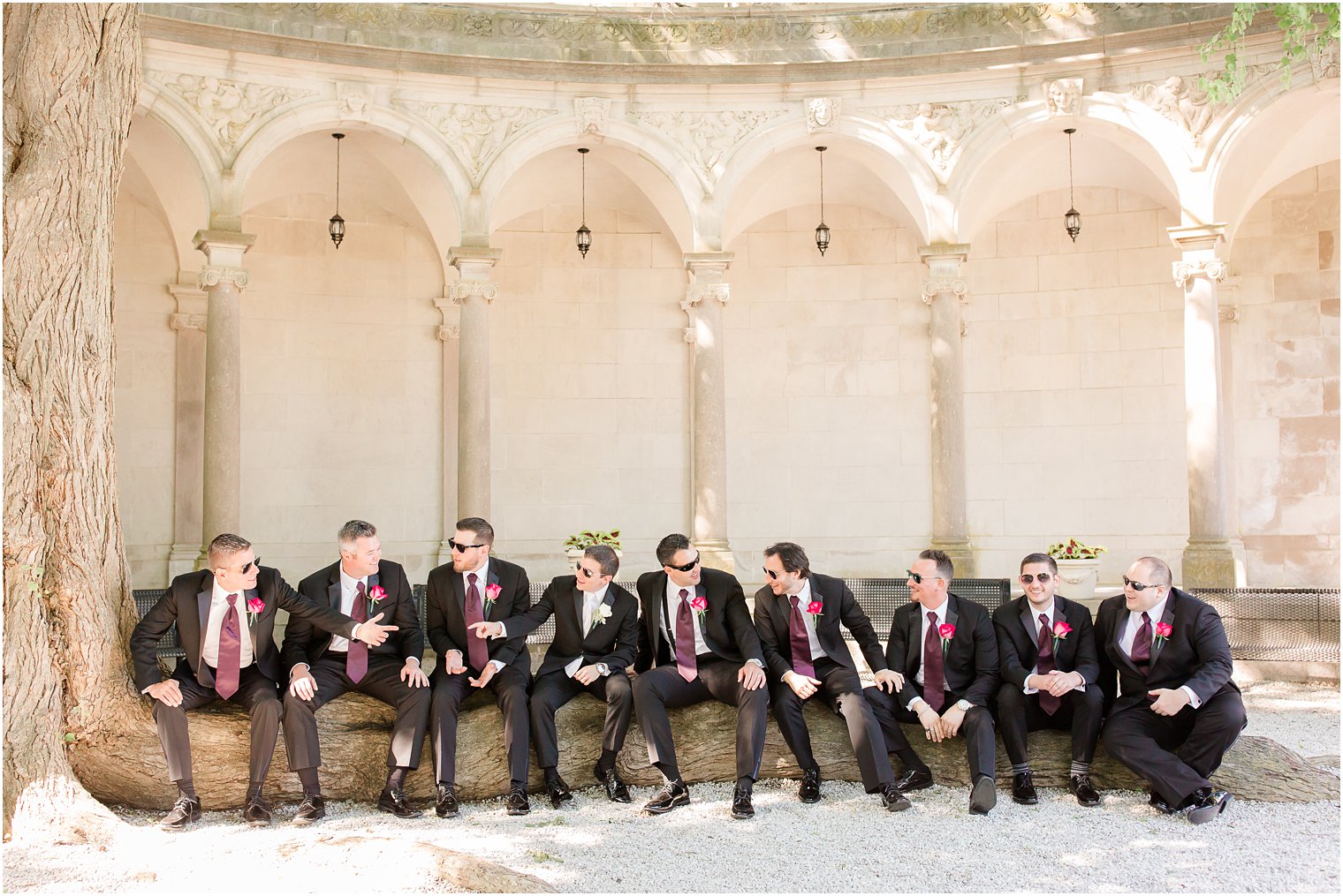 Groomsmen sitting on a tree stump