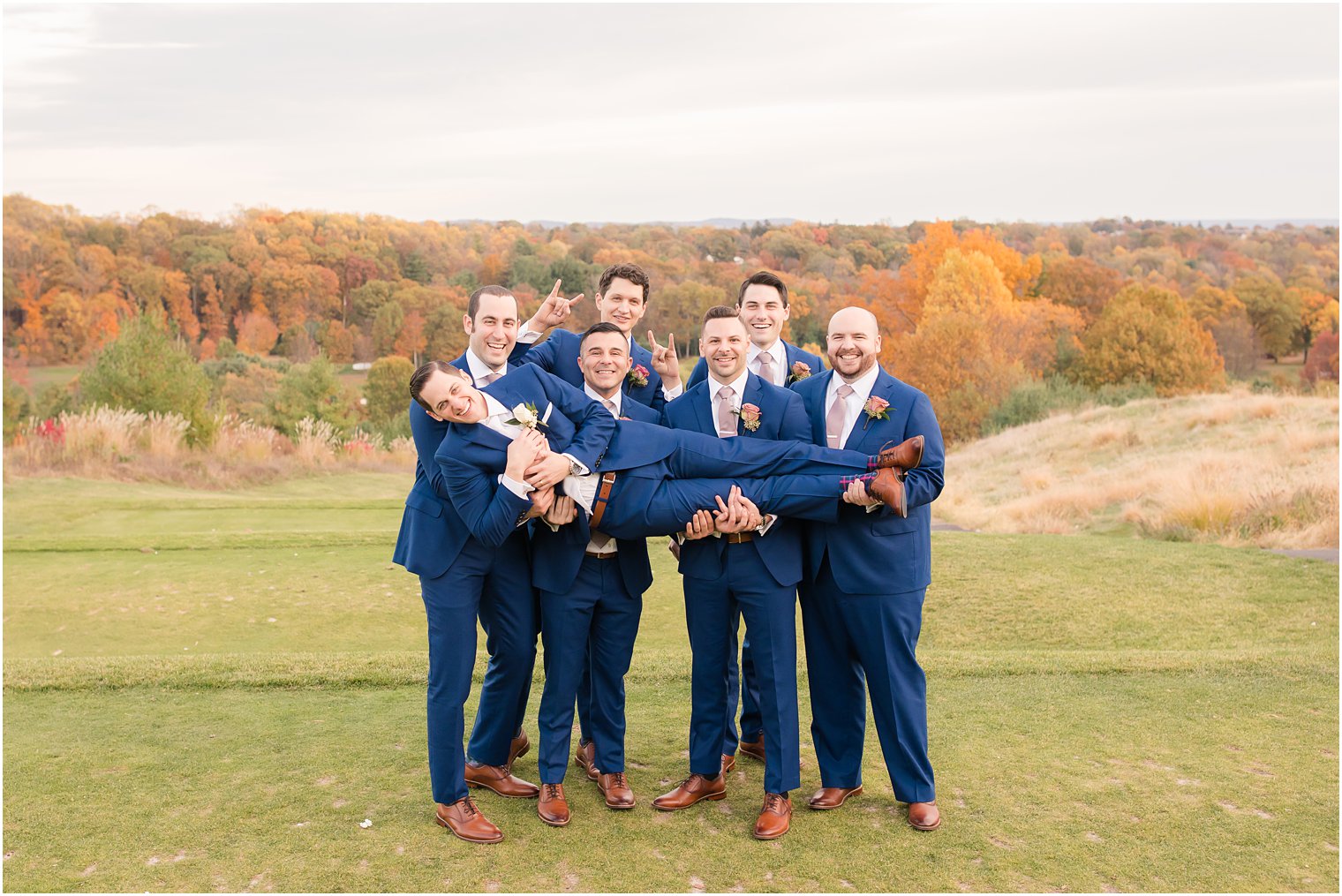 Groomsmen lifting groom