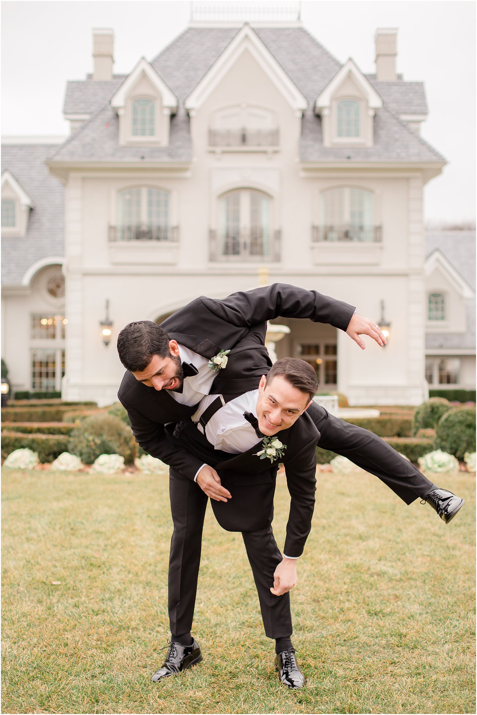 Groom lifting groomsman in silly photo