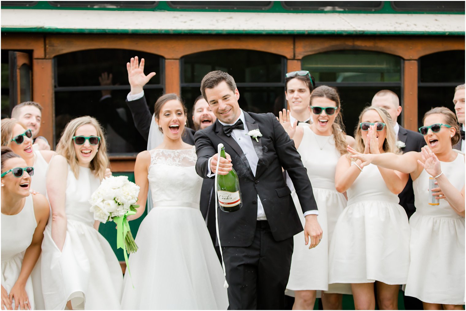 Bridal party opening bottle of champagne