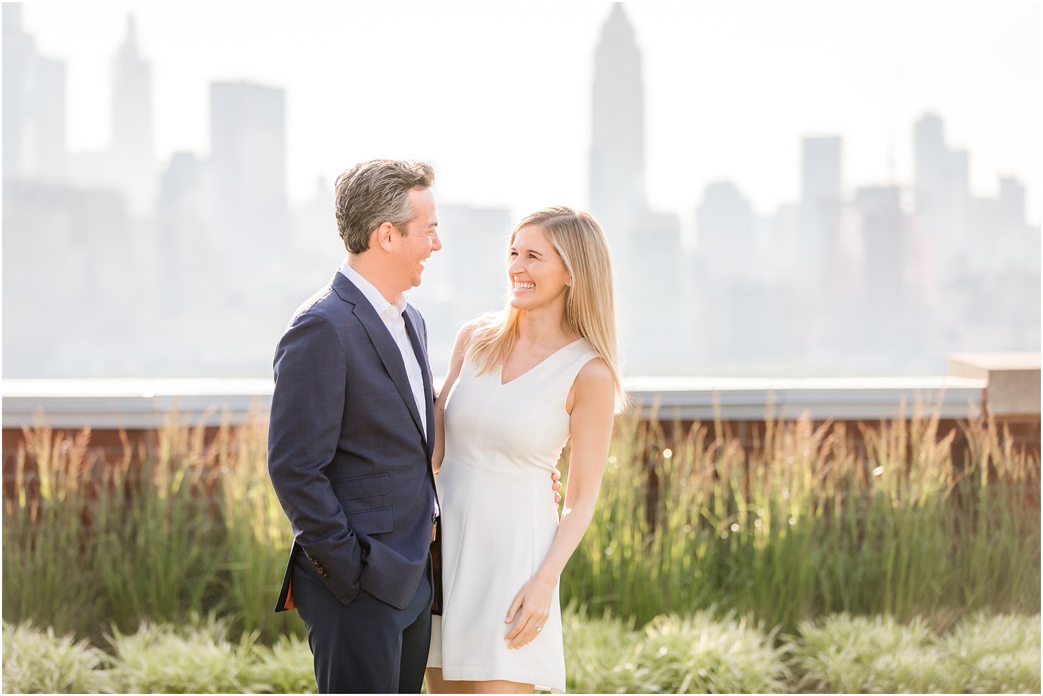 Bride smiling at groom | Hoboken Rooftop Engagement by Idalia Photography