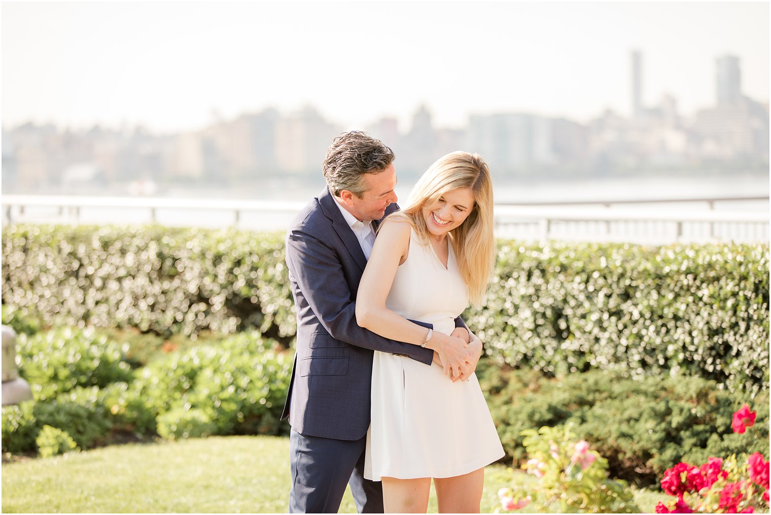 Groom tickling bride during Hoboken Rooftop Engagement by Idalia Photography
