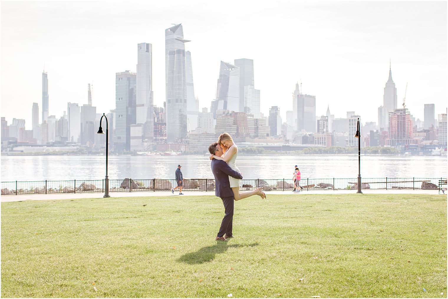 Groom lifting bride during Hoboken Rooftop Engagement by Idalia Photography