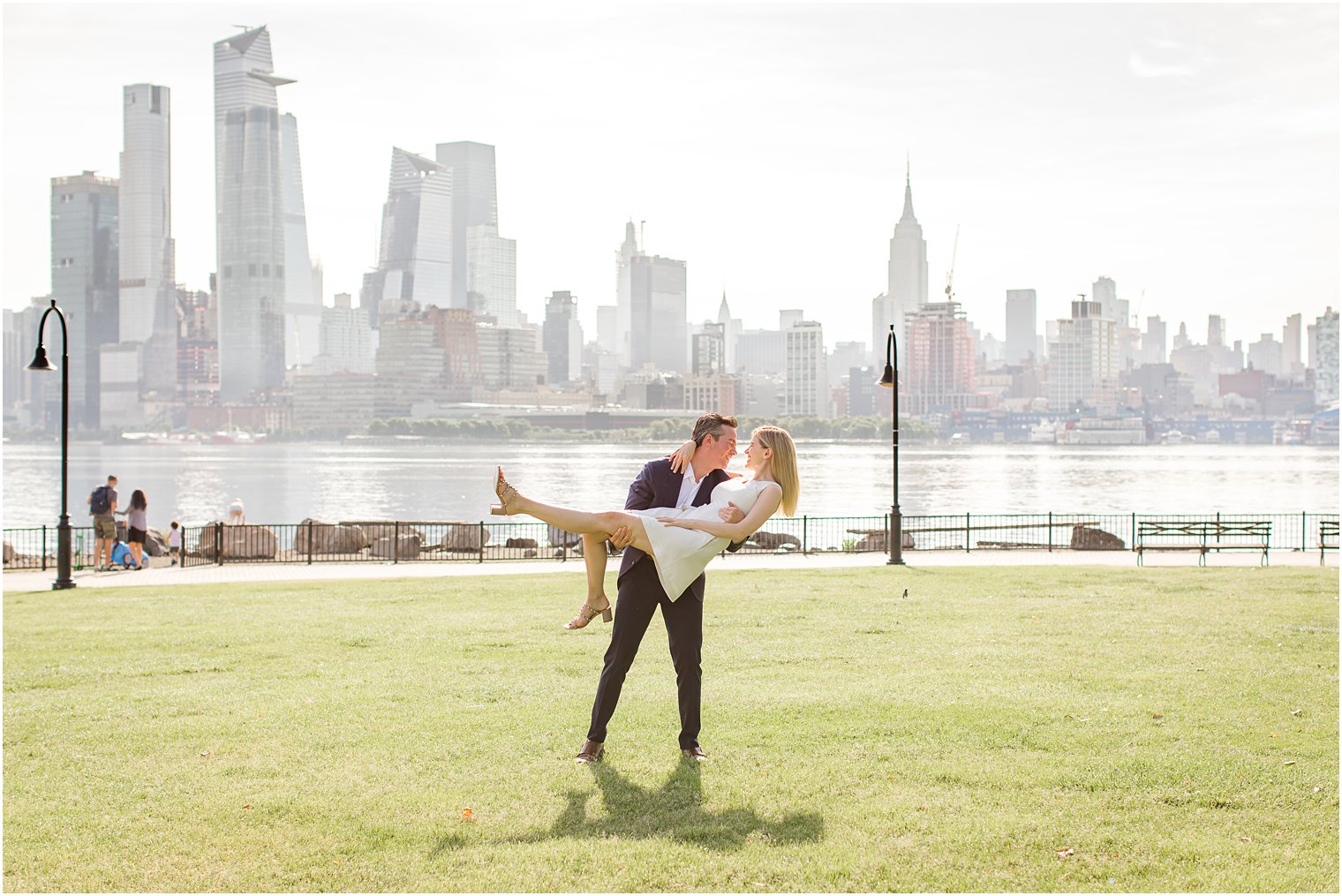 Groom lifting bride during Hoboken Rooftop Engagement by Idalia Photography