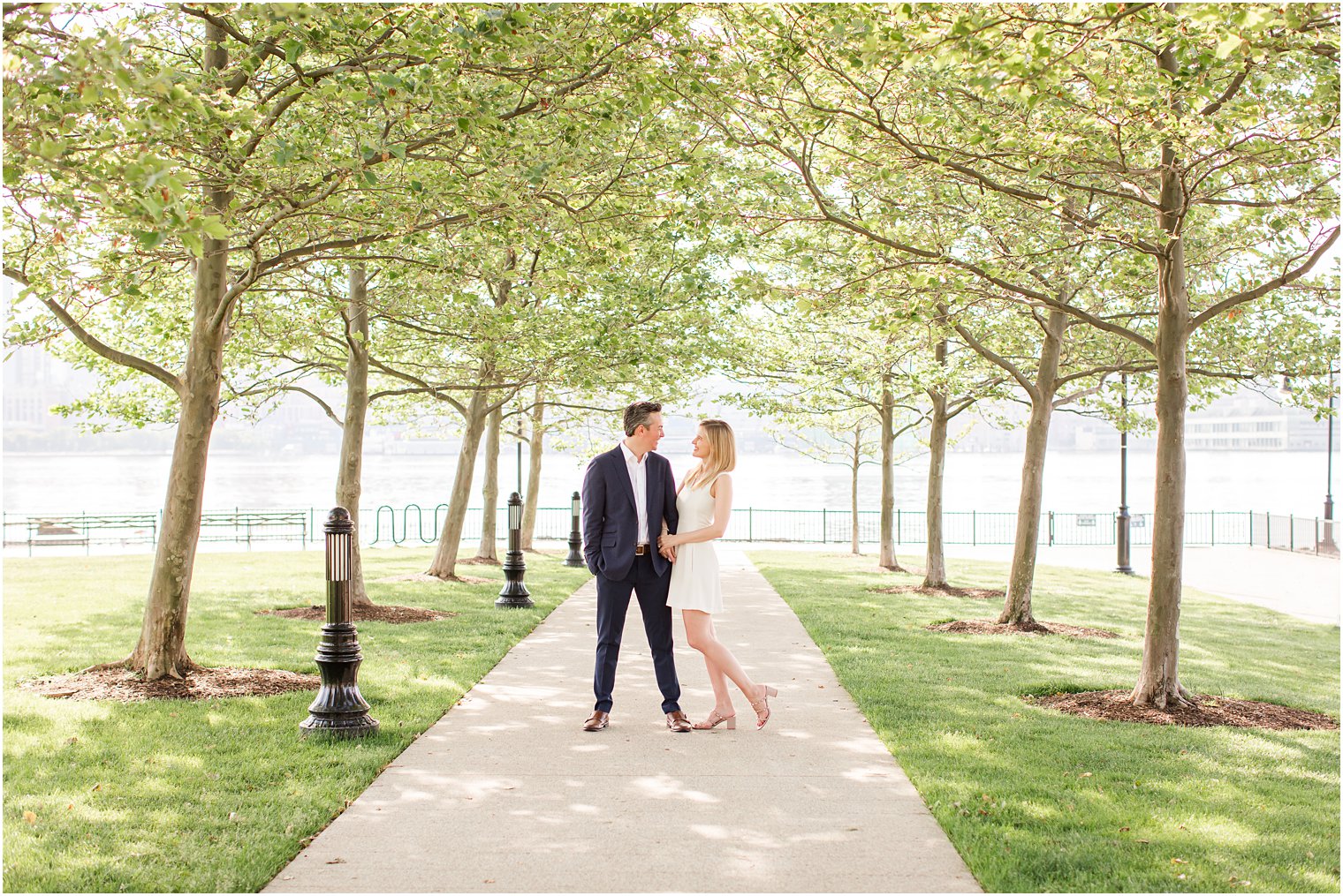 Bride and groom smiling at each other during Engagement photos at Hoboken park