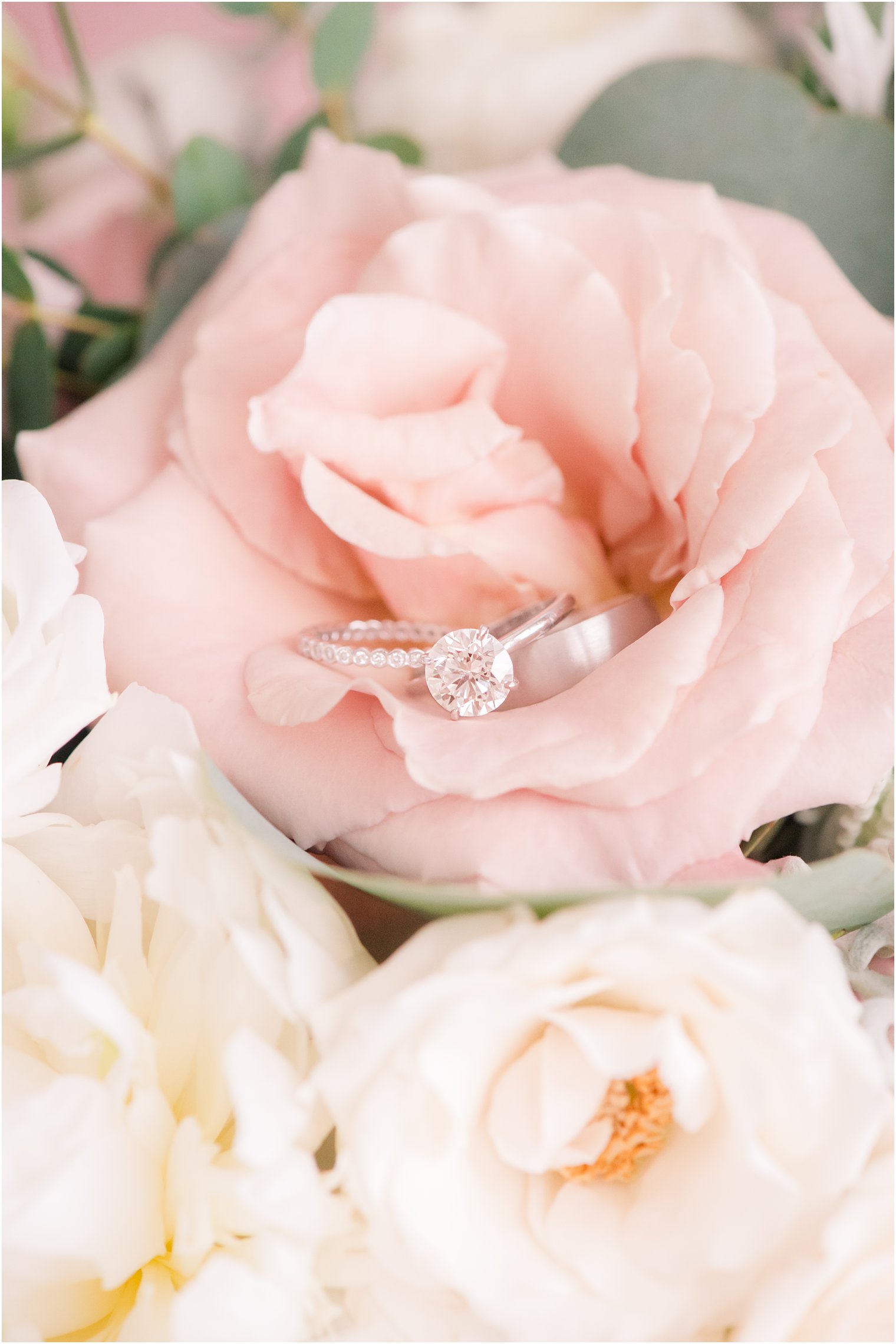 Engagement ring and wedding bands in bouquet