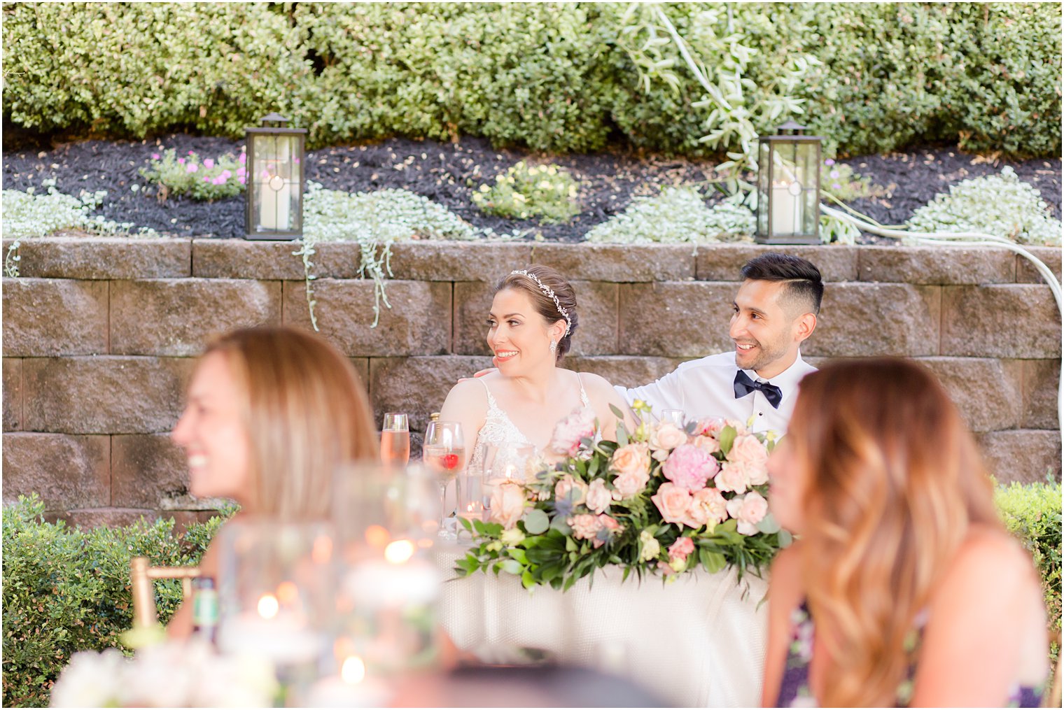 Bride and groom listening to speeches at outdoor wedding