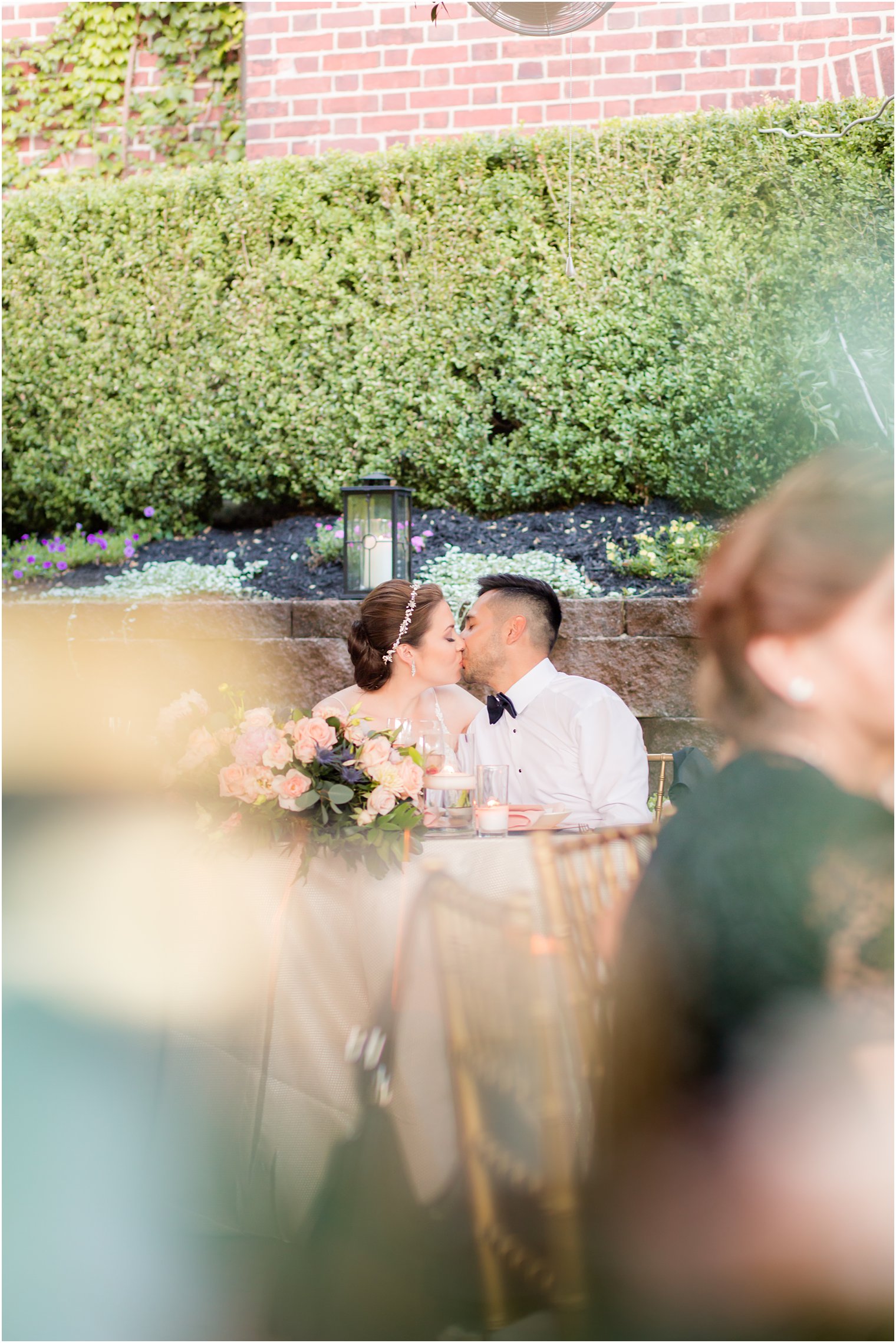 Bride and groom kissing at sweetheart table