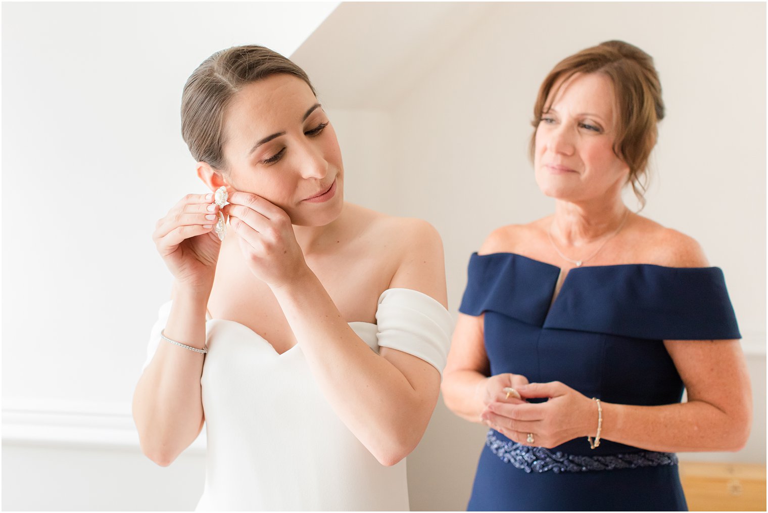 Bride putting on her earrings