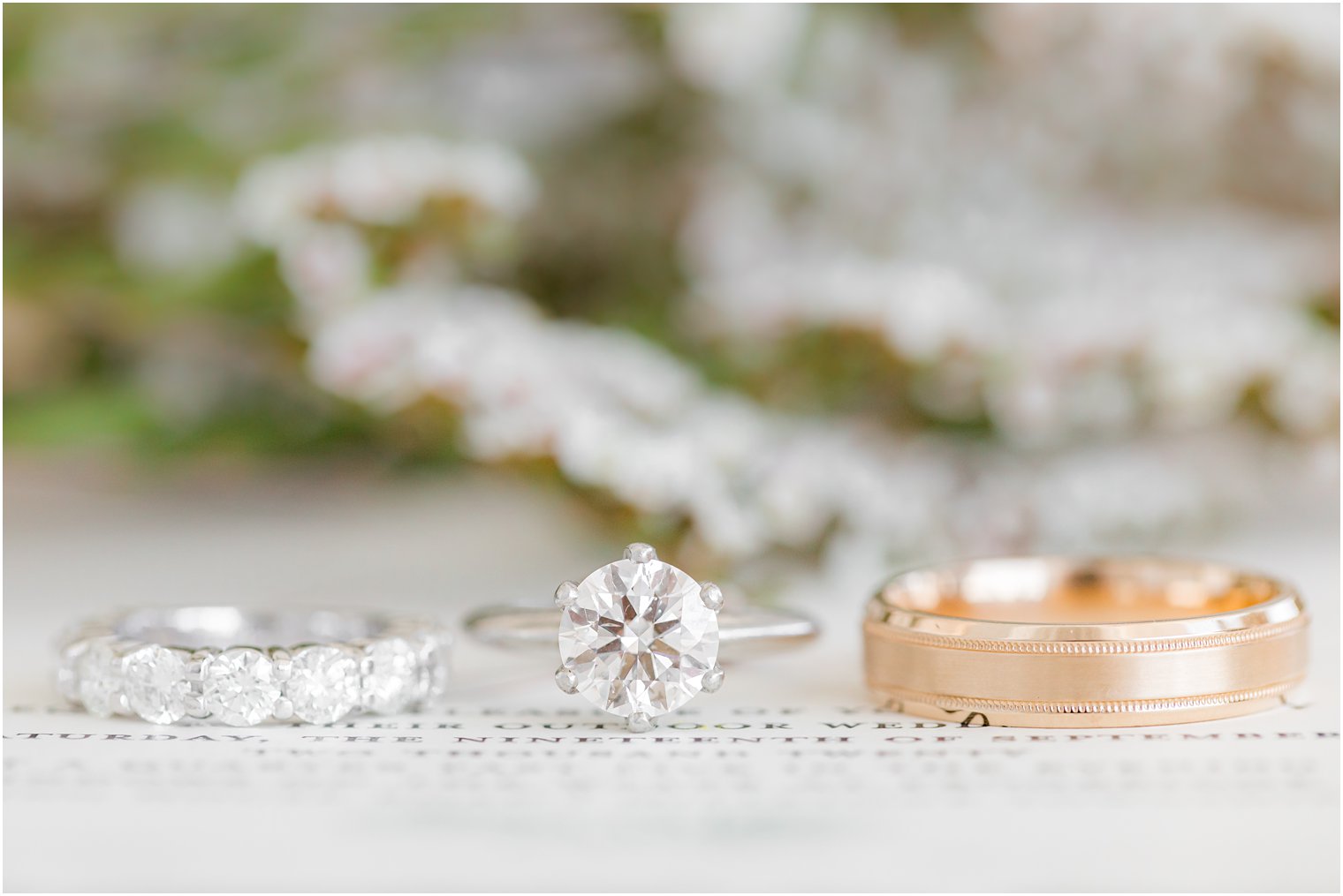 wedding rings sit on invitation before NJ wedding