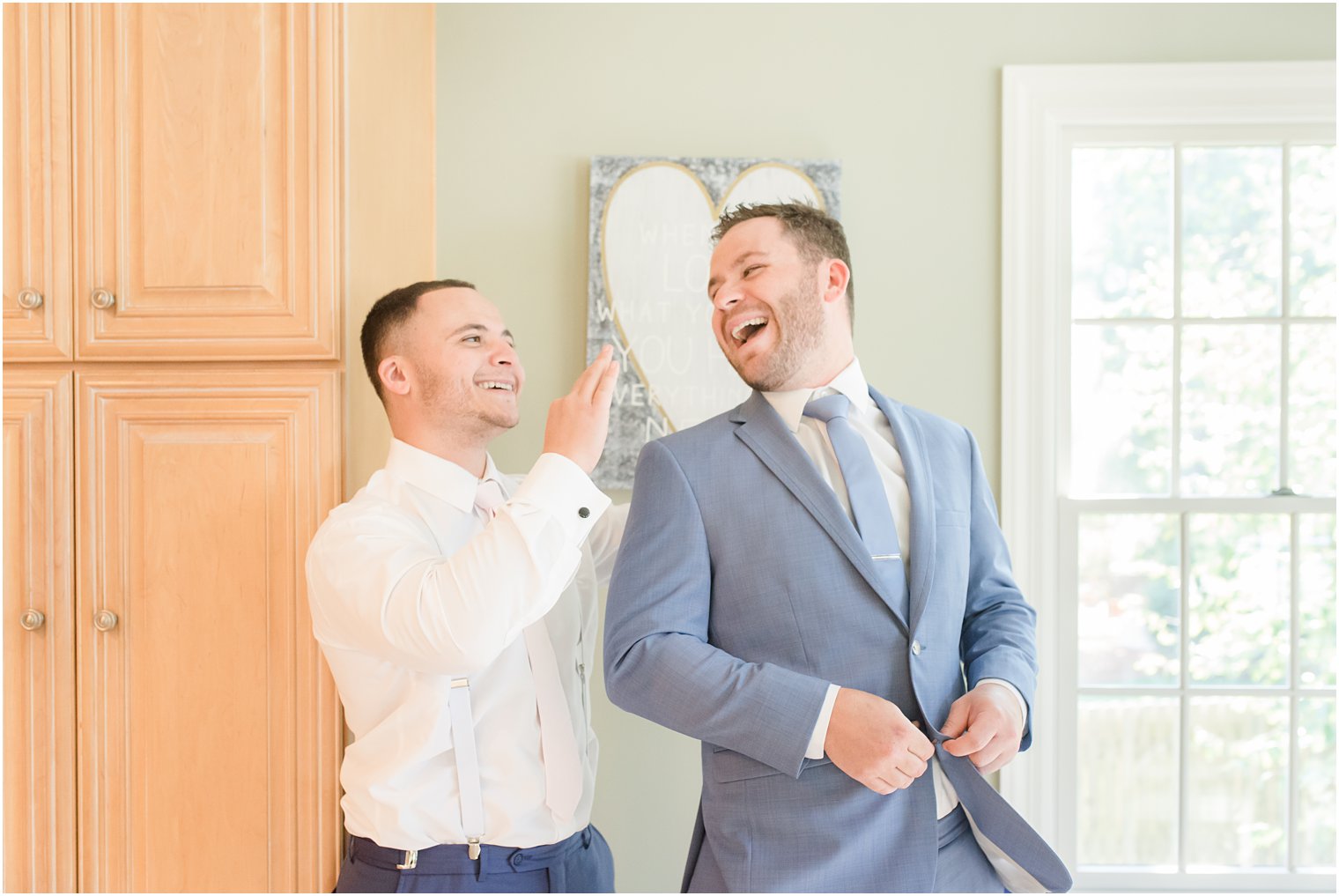 groom and friend laugh while preparing for Windows on the Water at Frogbridge wedding