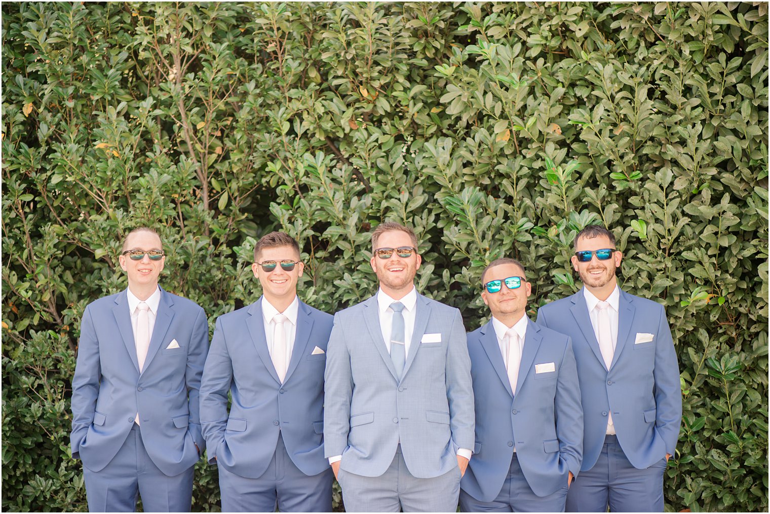 groom poses with four groomsmen in Millstone, NJ before wedding
