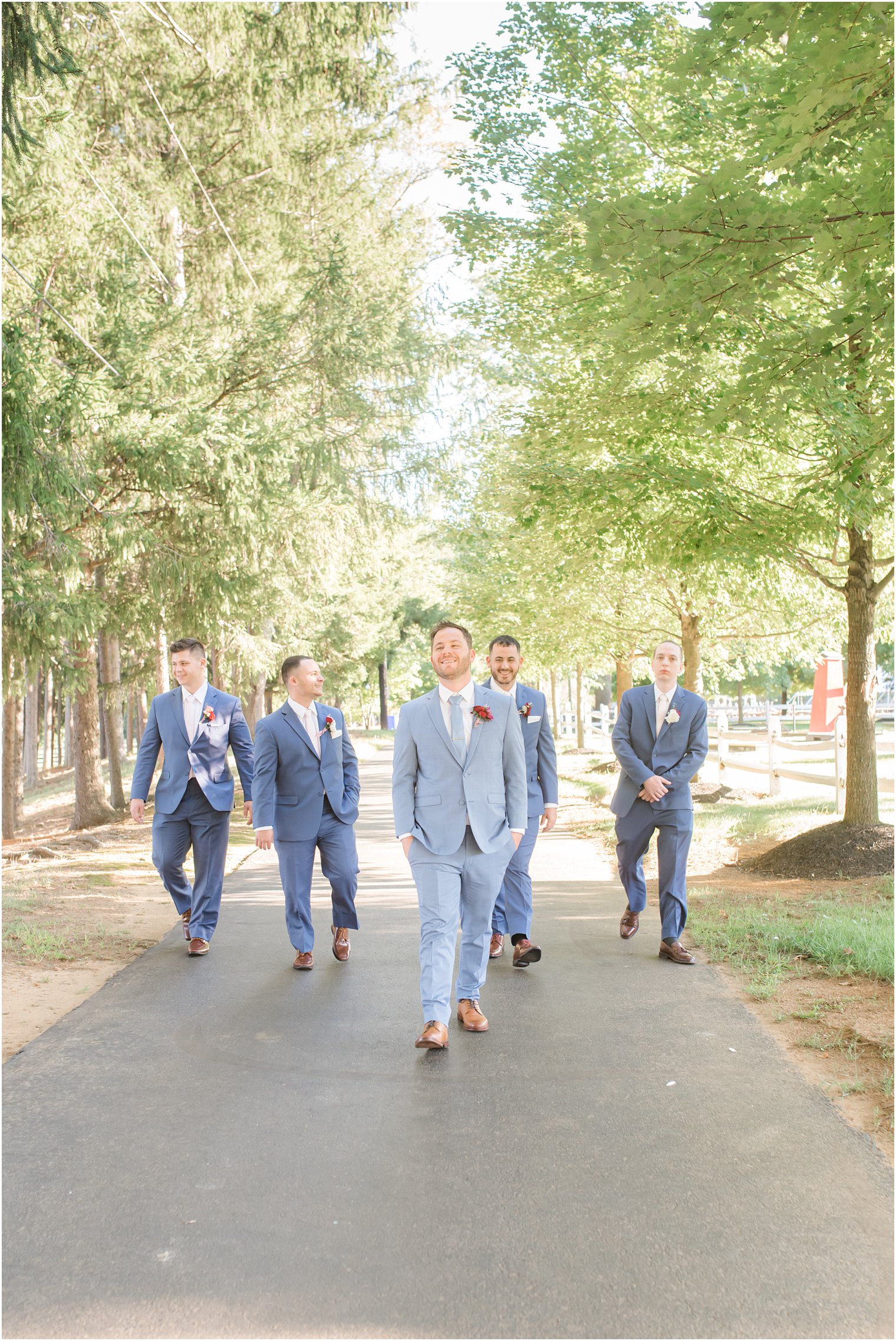 groom and groomsmen walk around Windows on the Water at Frogbridge