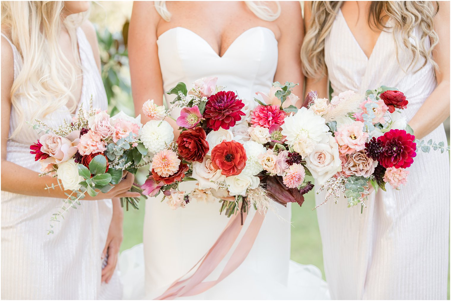 bride and bridesmaid hold bouquet with pink wildflowers before Windows on the Water at Frogbridge wedding