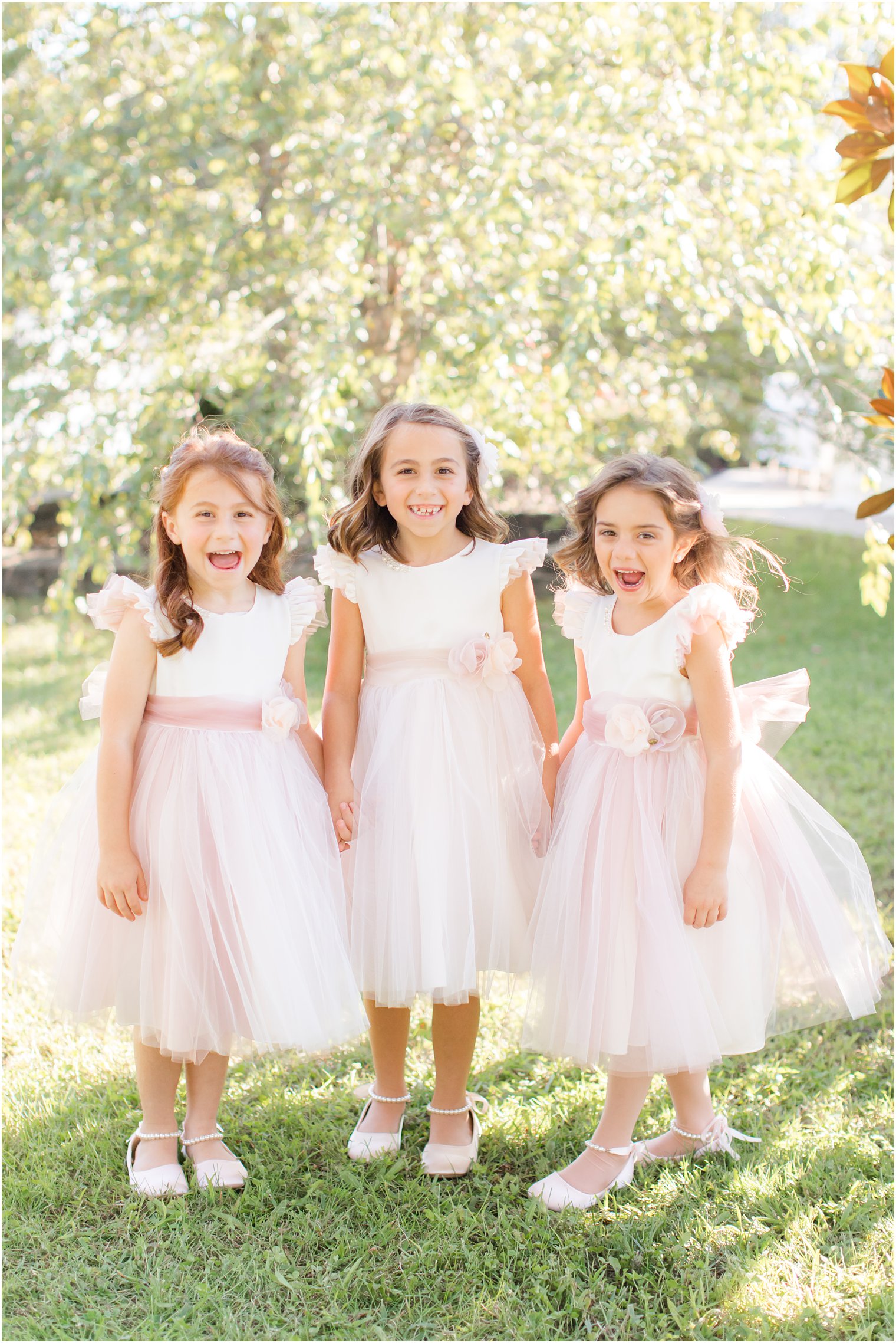 three flower girls in pink gowns laugh before New Jersey wedding