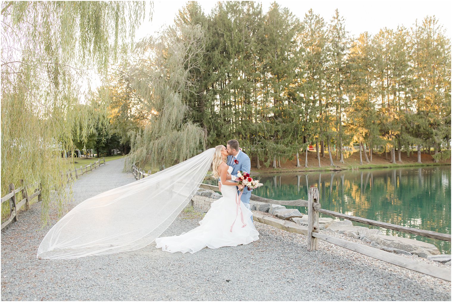 bride and groom kiss by lake at Windows on the Water at Frogbridge