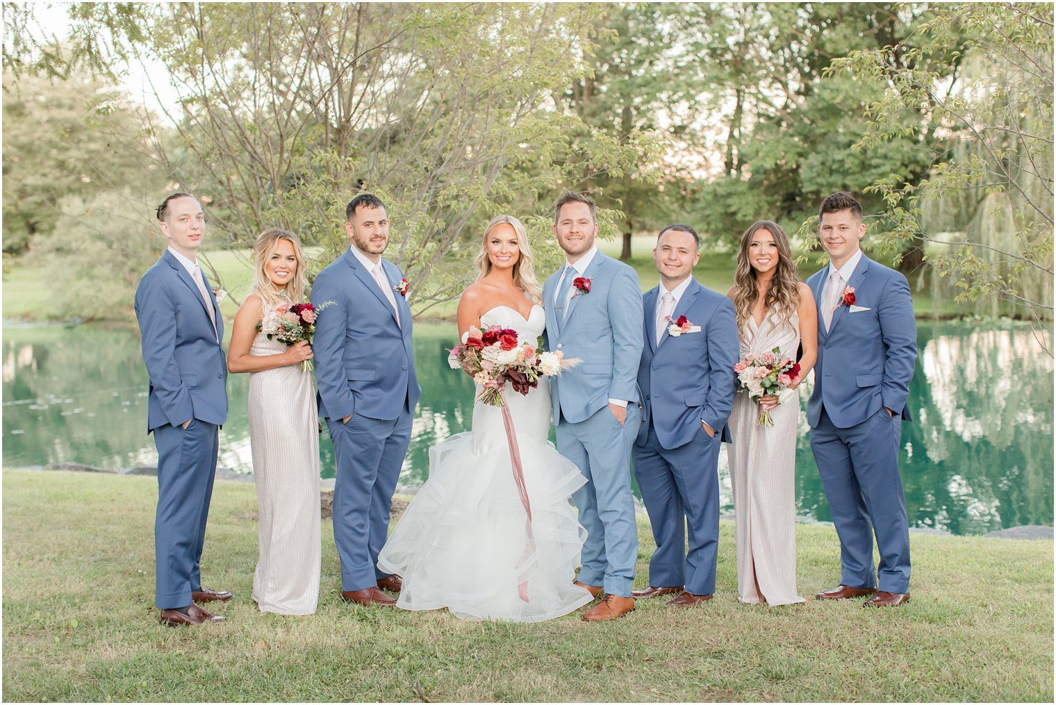 wedding party poses by lake at Windows on the Water at Frogbridge