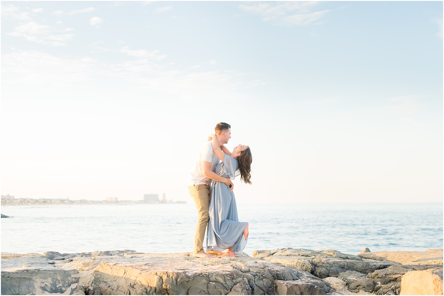 bride laughs standing on the rocks with groom 