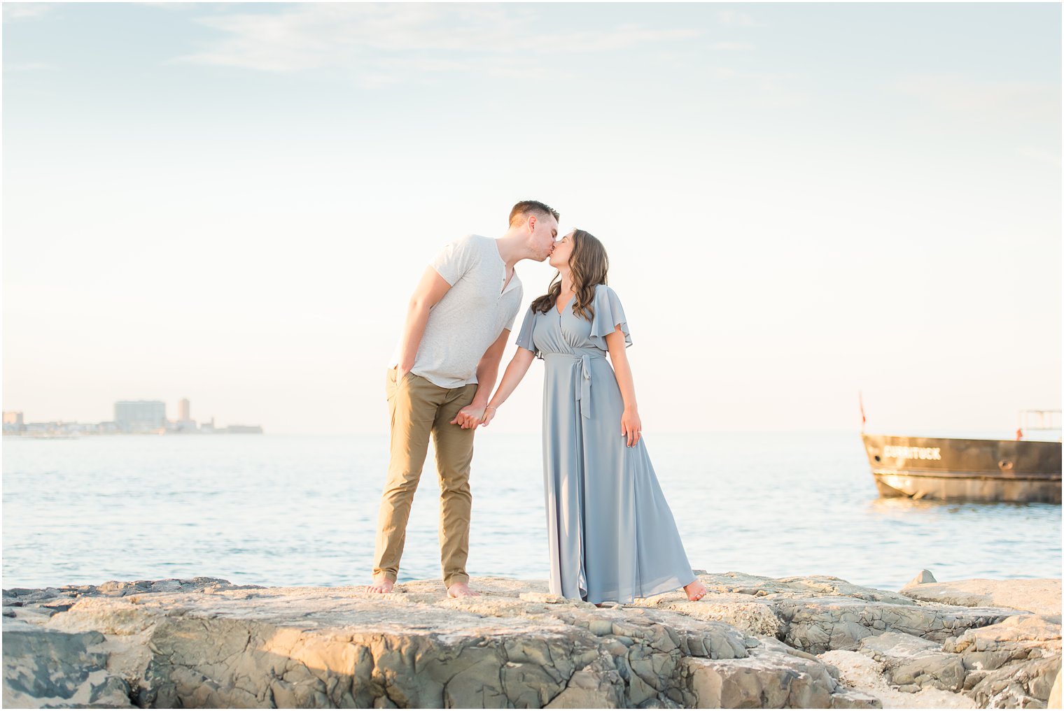 couple kisses standing on rocks during Belmar NJ Engagement Session