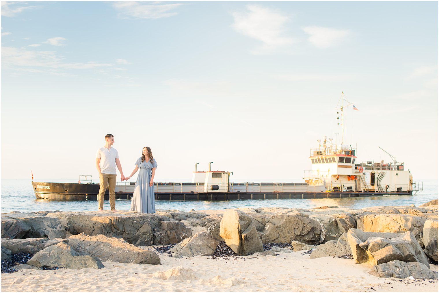 bride and groom walk along rocks during Belmar NJ Engagement Session