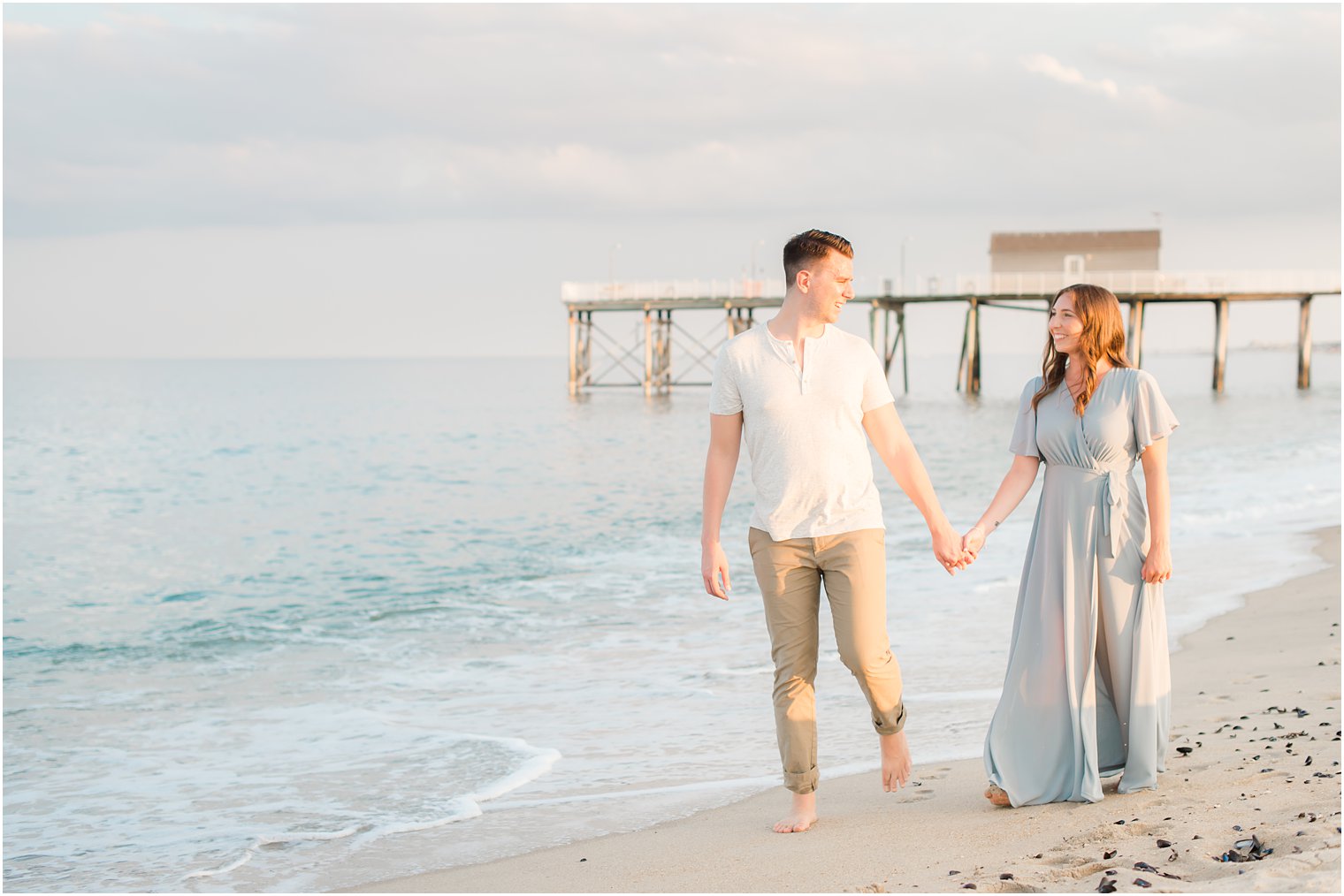 engaged couple walks along ocean during Belmar NJ Engagement Session