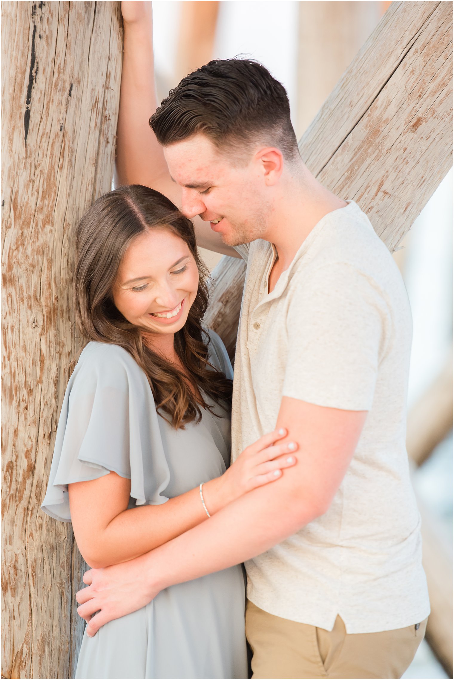 groom makes bride laugh during New Jersey beach engagement session