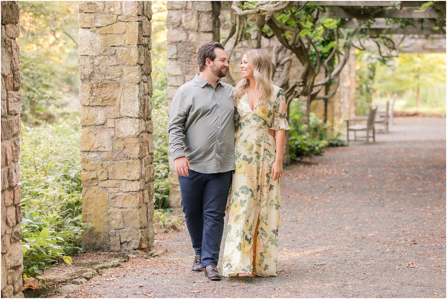 engaged couple walks through New Jersey gardens during engagement photos