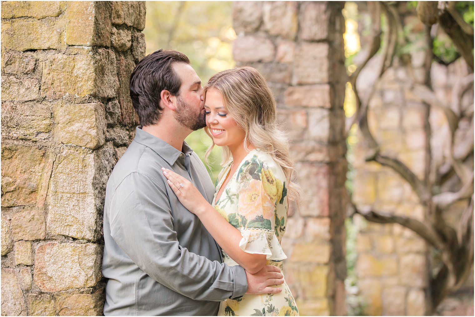 new Jersey couple poses under pergola while groom kisses bride's cheek