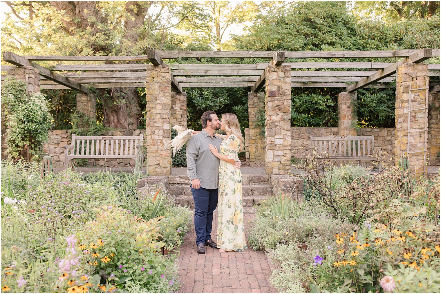 bride and groom kiss in front of Cross Estate Gardens pergola