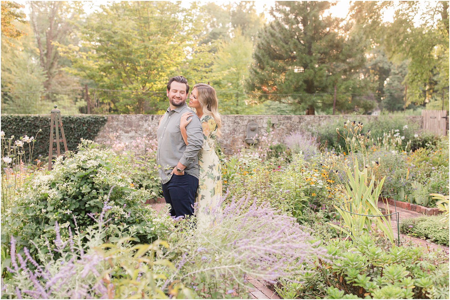 bride hugs groom from behind in lavender garden