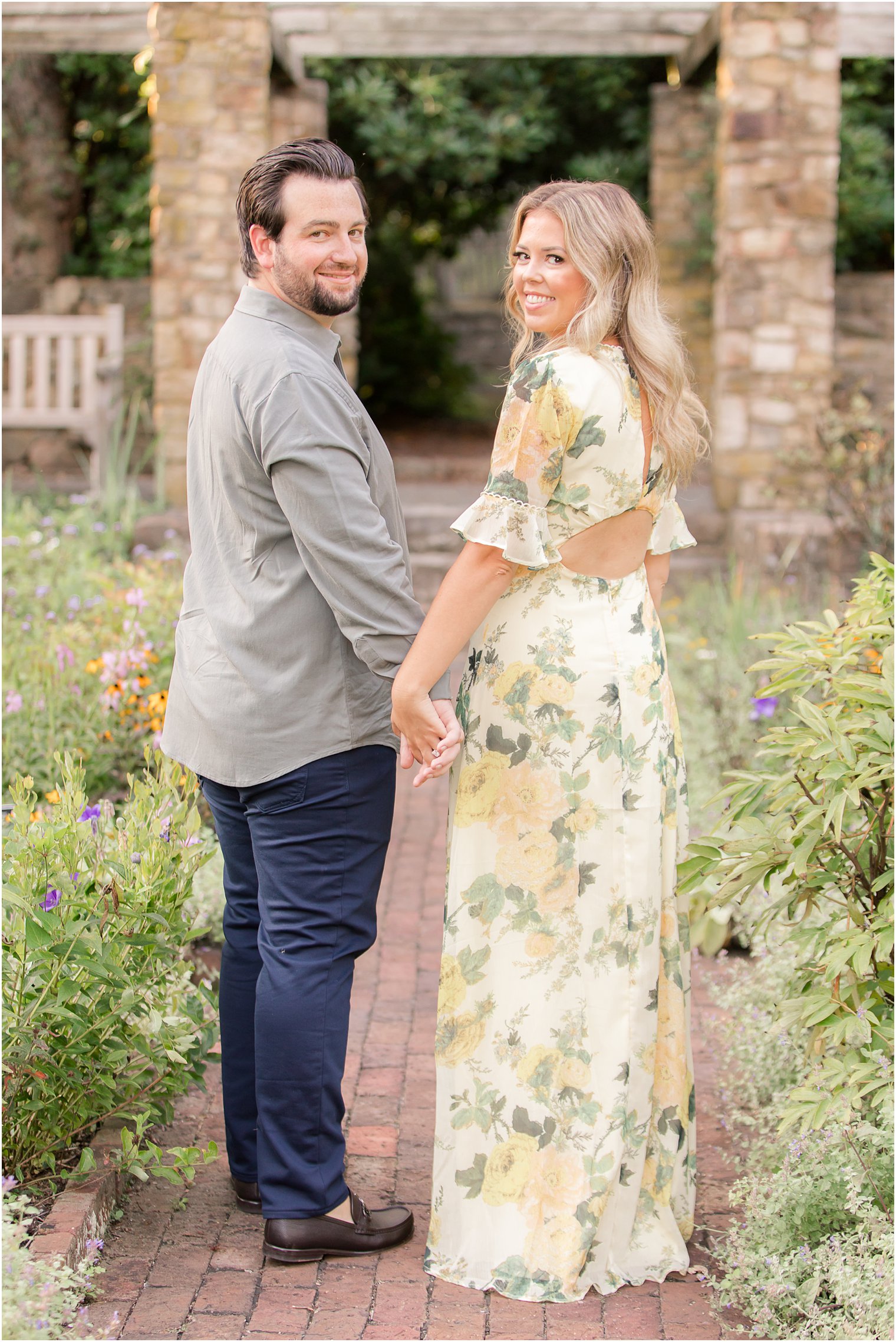 bride and groom hold hands and look over shoulders