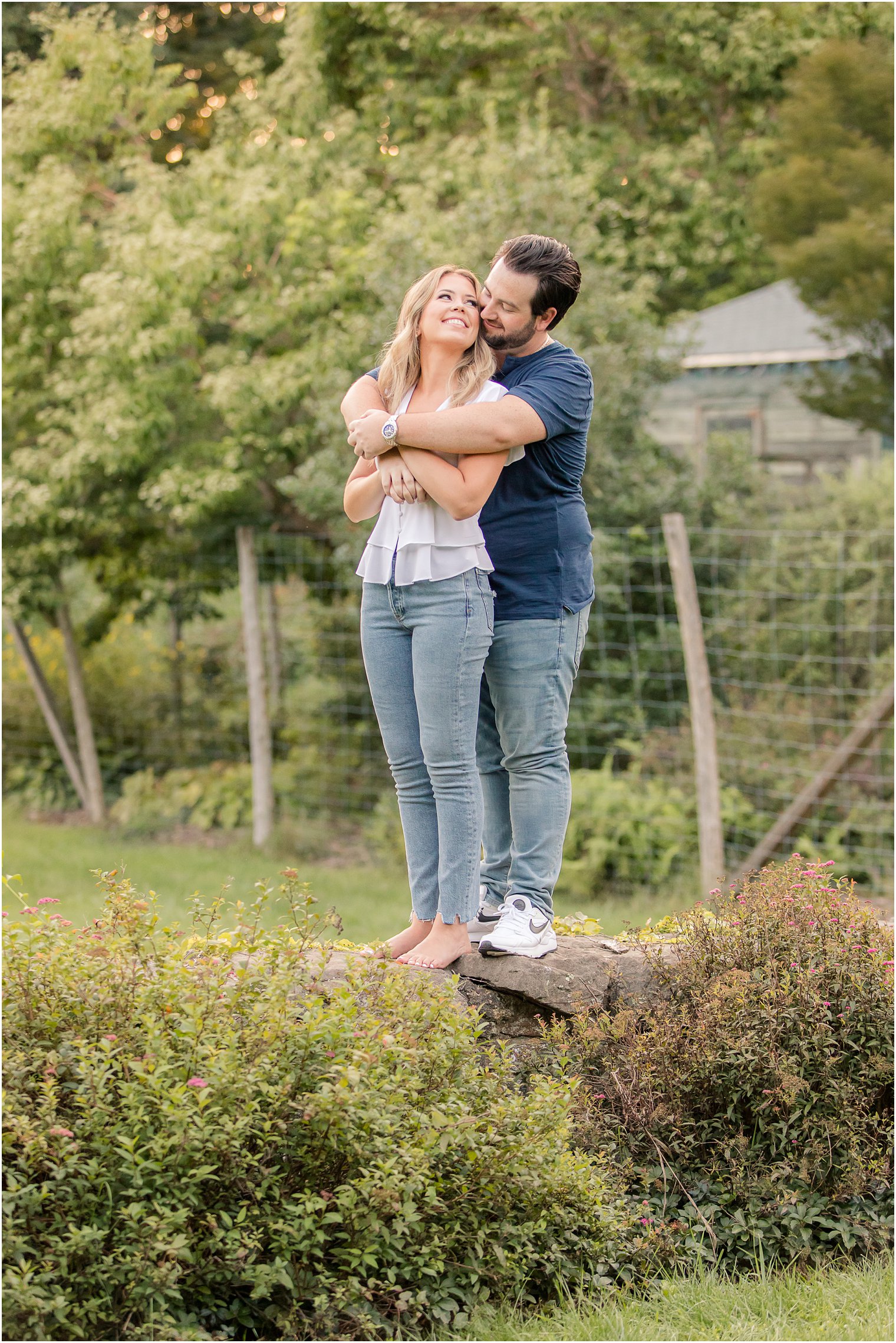 bride and groom stand on rocks at Cross Estate Gardens