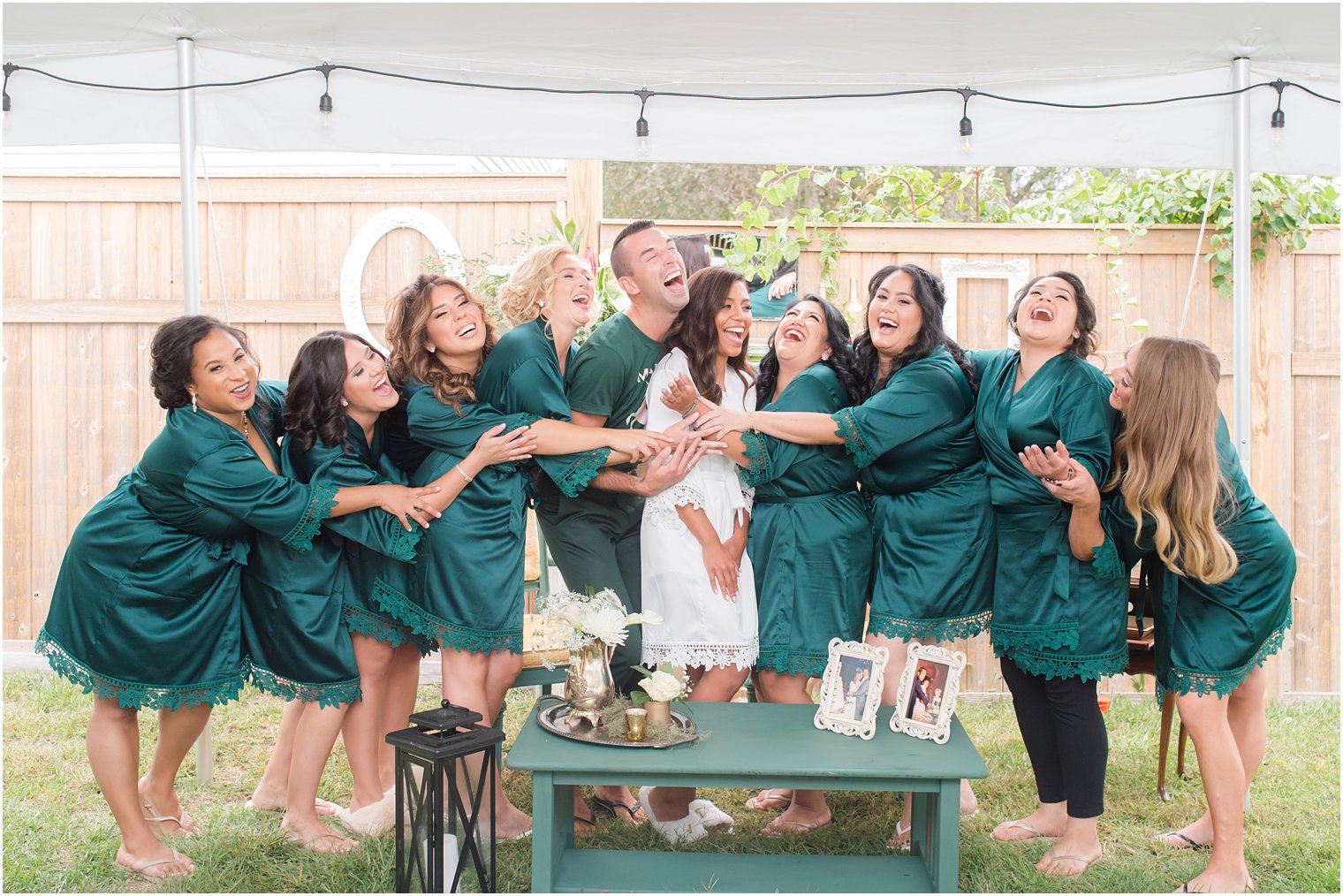 bridesmaids and man of honor hug bride during wedding morning prep