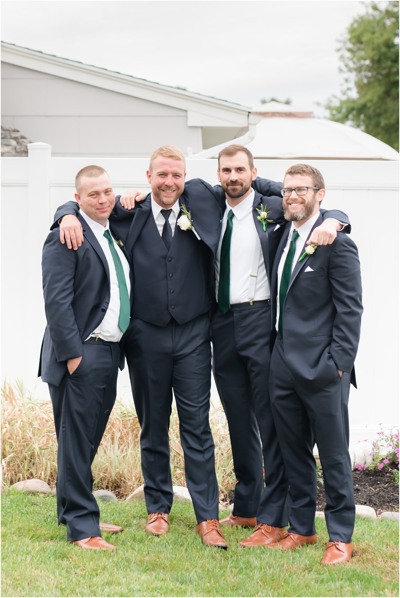 groom poses with three groomsmen before Toms River NJ wedding