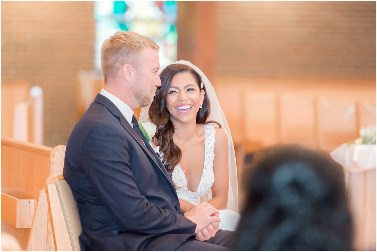 newlyweds laugh during mass at traditional Toms River NJ church wedding