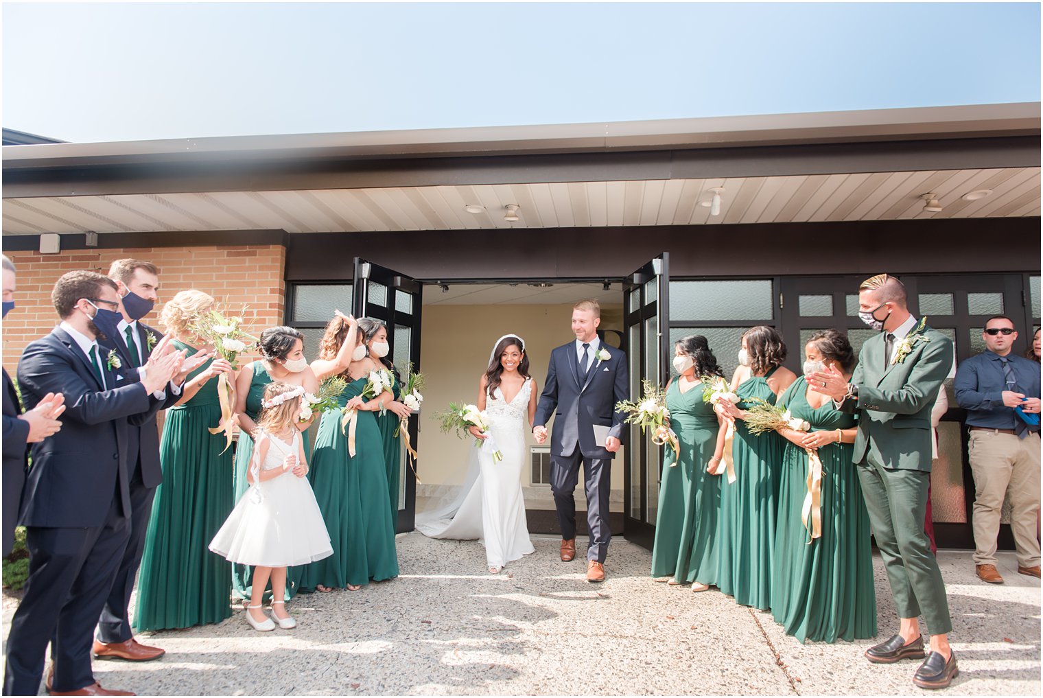 bride and groom leave New Jersey church with bridal party cheering