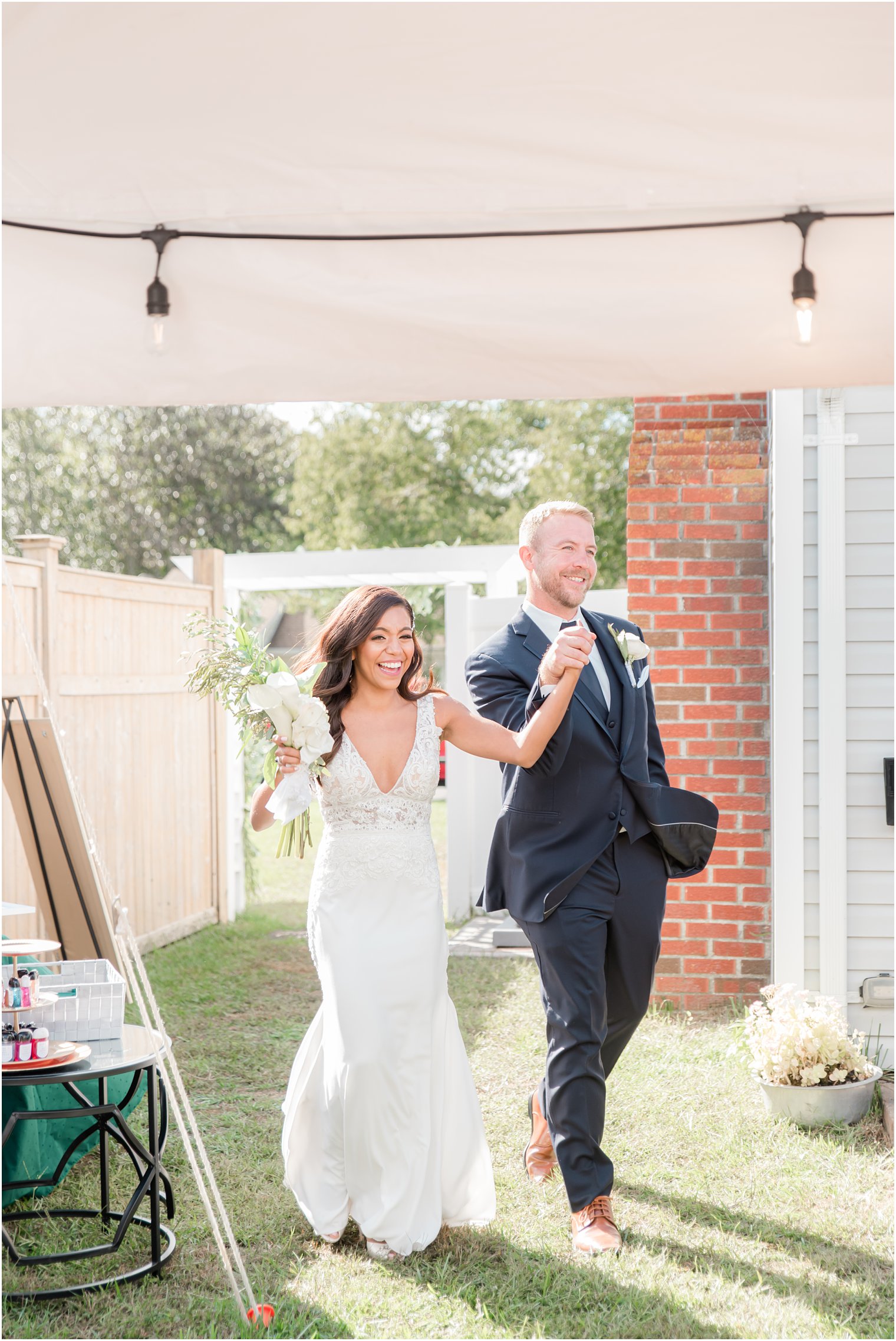 bride and groom enter backyard wedding reception