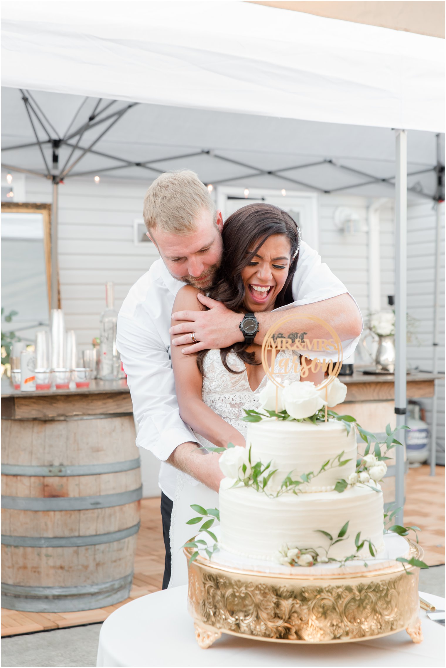 bride and groom cut tiered wedding cake during backyard wedding in Tom's River