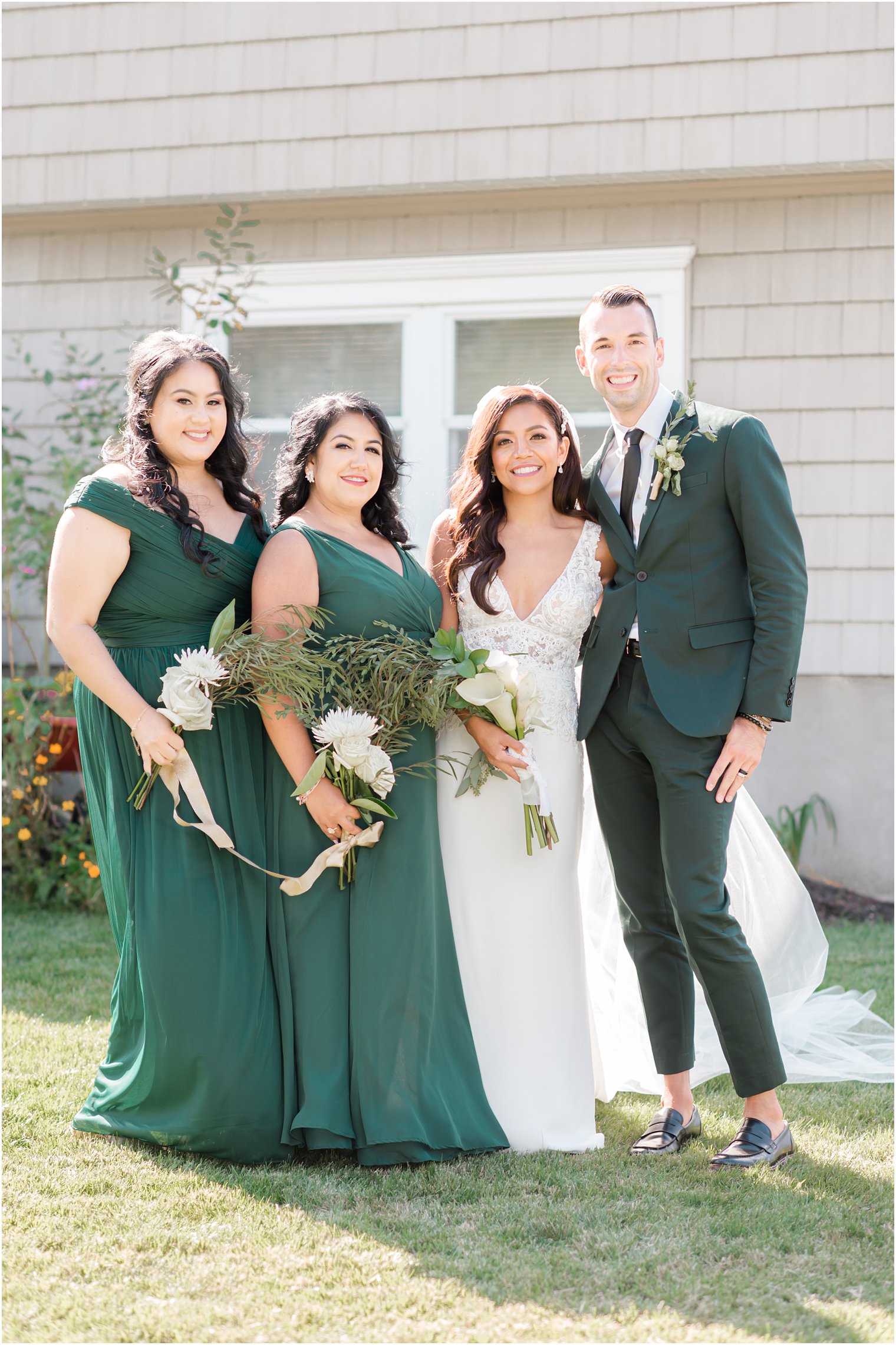 bride poses with bridesmaids and best man