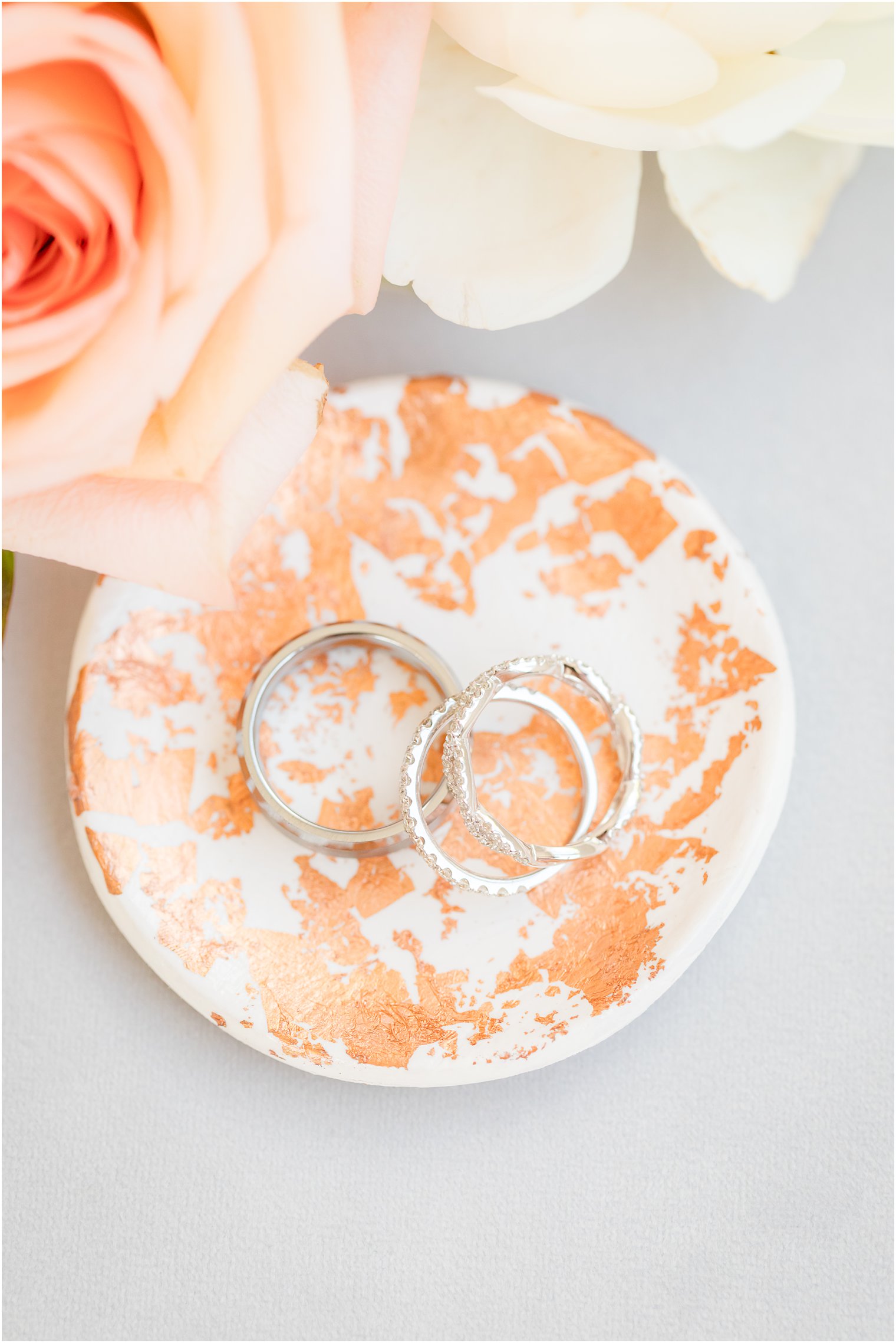 wedding rings rest on copper speckled ring dish