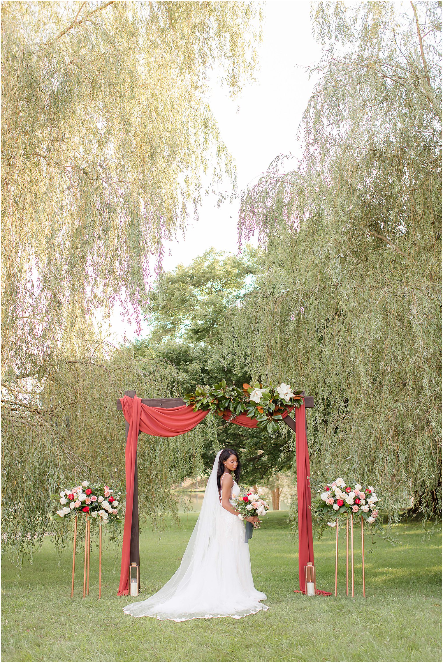 bride poses by ceremony arch at WOTW