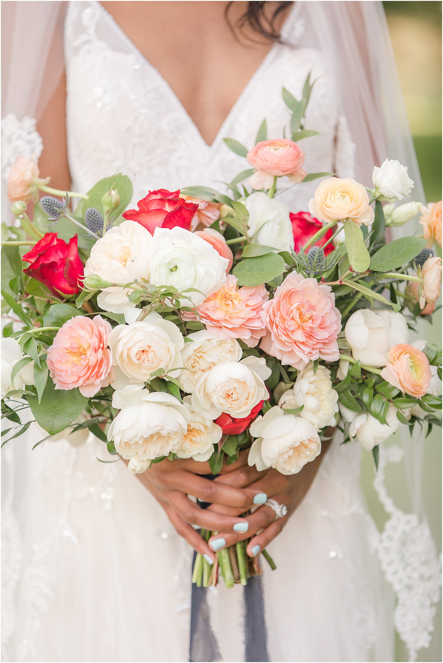 bride holds bouquet of pink and orange flowers for fall wedding