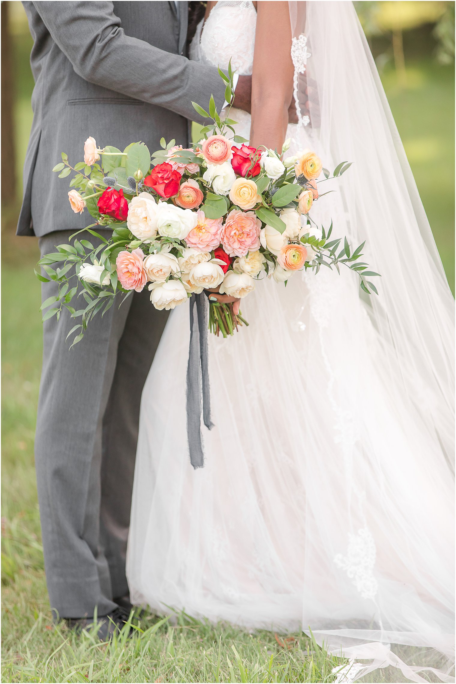 bride holds bouquet with grey ribbon for fall wedding