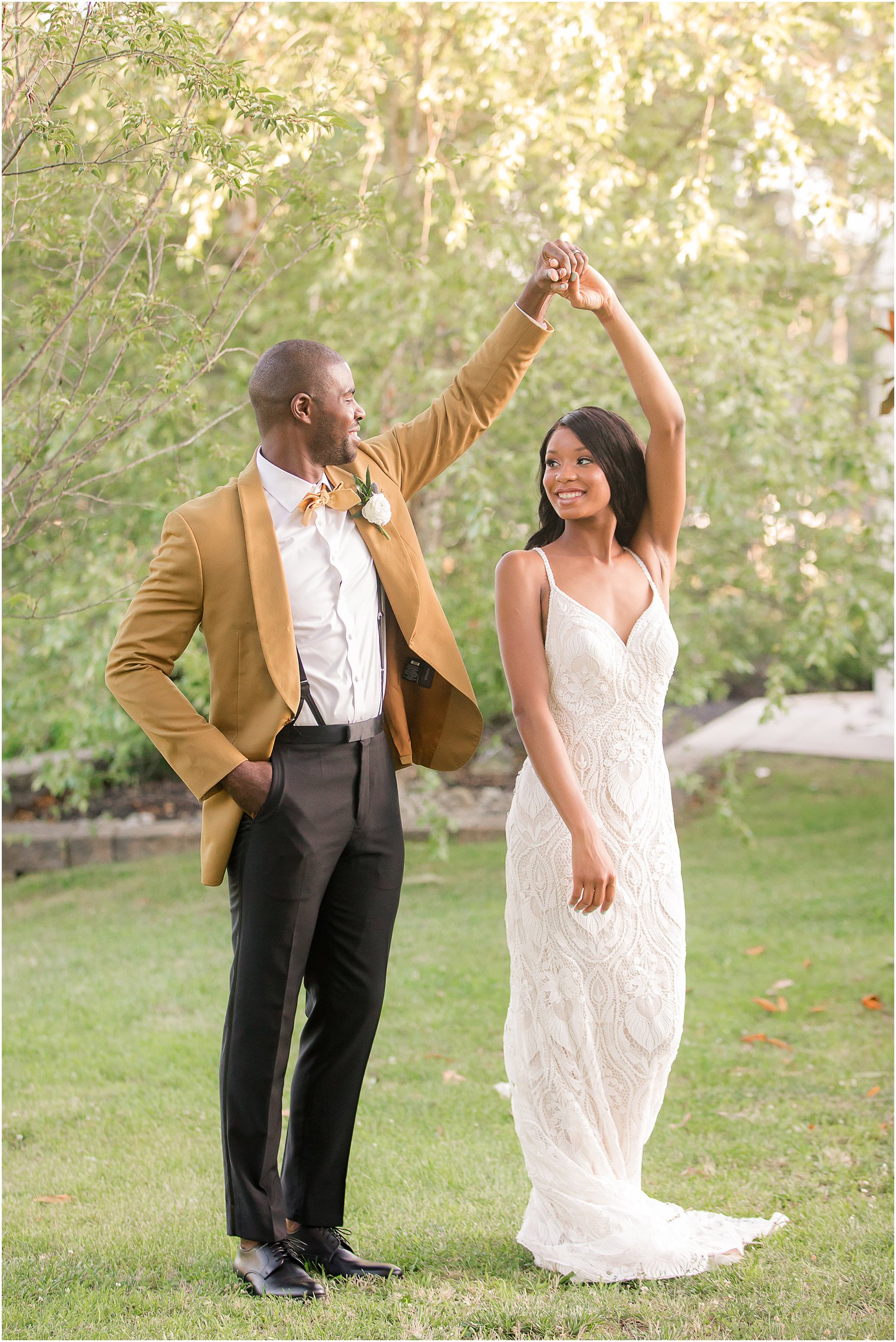 groom in mustard suit jacket twirls bride during wedding reception dances